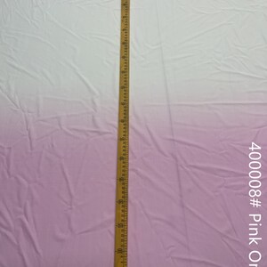 May include: A close-up of a light pink ombre fabric with a wooden ruler measuring 24 inches. The fabric is smooth and has a slight sheen. The text "400008# Pink Ombre" is visible in the bottom right corner of the image.