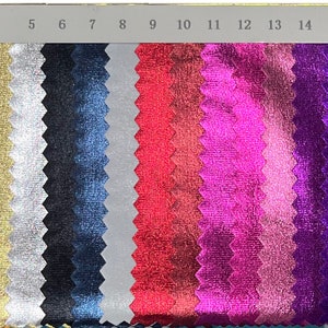 May include: A colour swatch displaying a range of metallic fabric samples. The samples vary in colour, from gold and silver to shades of blue, pink, and red. Numbers 1 to 18 are printed along the top of the swatch.