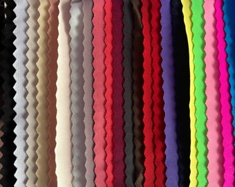 May include: A color swatch card featuring twenty-three vertical fabric strips with a wavy, scalloped edge. The strips display a gradient of colors including black, white, beige, gray, pink, red, brown, purple, navy, yellow, lime green, and blue.