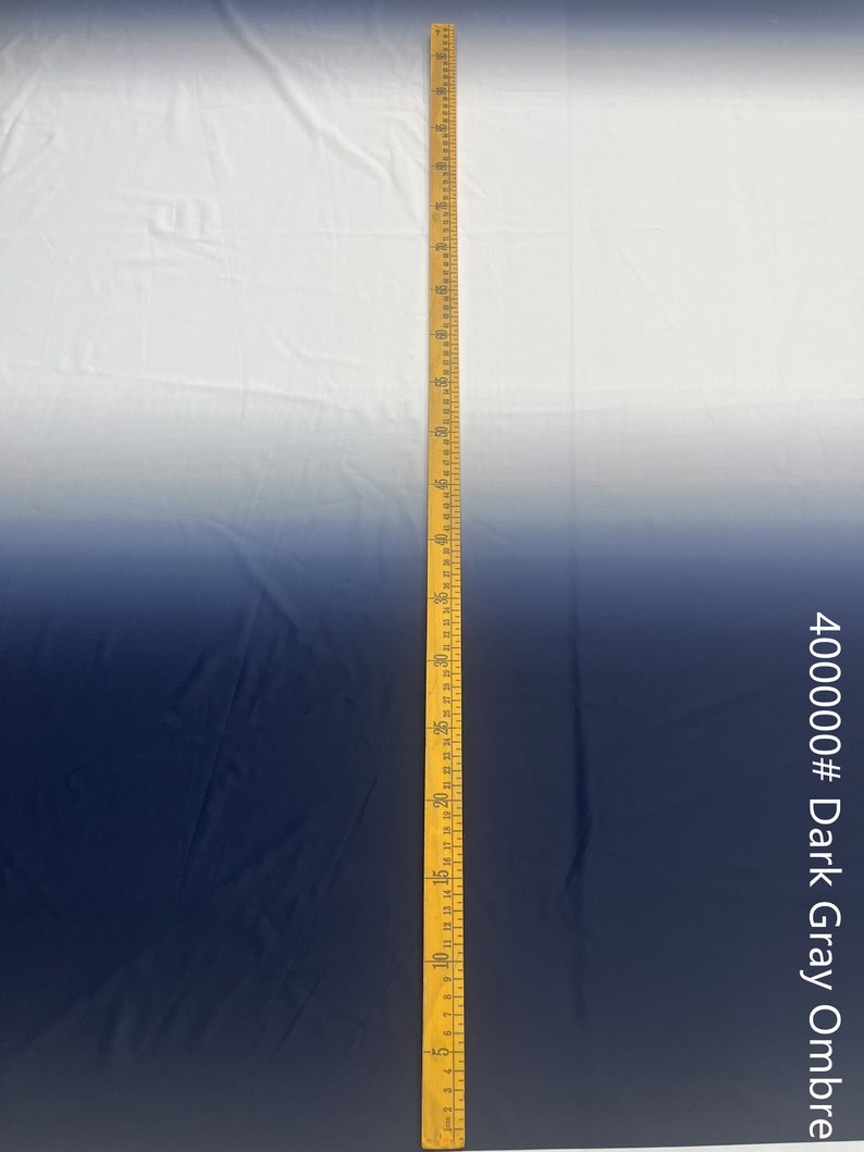 May include: A white to dark gray ombre fabric with a yellow measuring tape along the right side. The tape measures 70 inches. The text "400000# Dark Gray Ombre" is on the right side of the image.