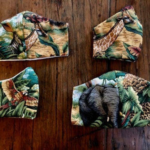 May include: Four fabric face masks with a jungle animal print. The masks feature a giraffe, a parrot, an elephant, and a leopard. The masks are all made of a soft, comfortable fabric and are perfect for everyday use.