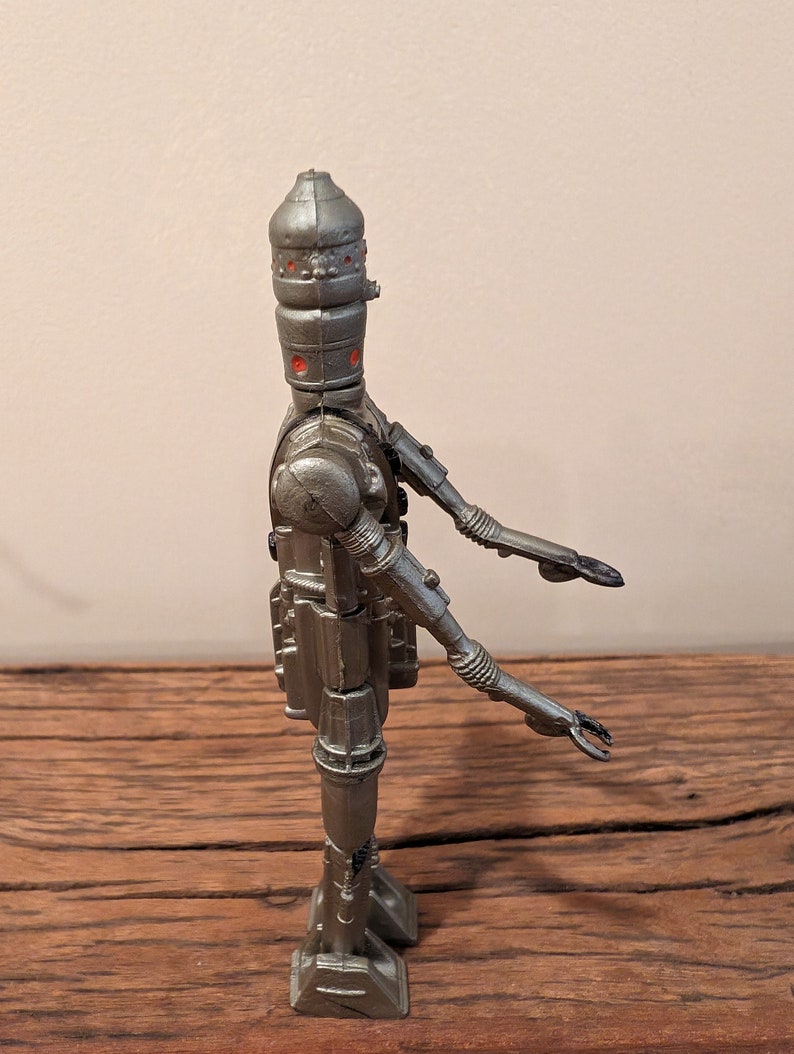 Peut inclure: Une figurine d'action Star Wars en argent d'un dro&iuml;de avec une t&ecirc;te en forme de d&ocirc;me et des bras et des jambes articul&eacute;s.