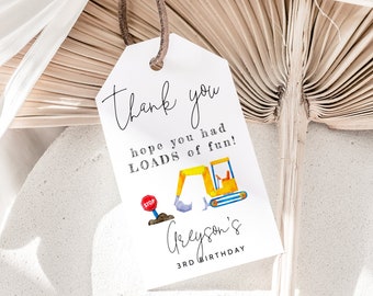 May include: A white gift tag featuring a yellow digger and a stop sign illustration. The tag says "thank you, hope you had LOADS of fun!" and "Greyson's 3rd Birthday". The tag is attached to a brown string.