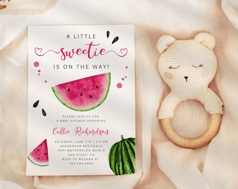 May include: A baby shower invitation with a watermelon theme. The invitation reads "A Little Sweetie Is On The Way!" and includes a watercolor watermelon slice and seeds. A knitted bear-shaped teether with a wooden ring is next to the invitation.