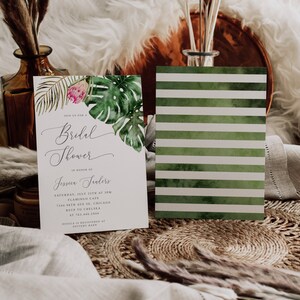 Puede incluir: Una invitaci&oacute;n a un baby shower de tem&aacute;tica tropical con una tarjeta RSVP a rayas verdes y blancas. La invitaci&oacute;n presenta una ilustraci&oacute;n de acuarela de hojas tropicales y una flor rosa. El texto dice "&Uacute;nete a nosotros para un Baby Shower en honor a Jessica Sanders S&aacute;bado, 25 de julio a las 3:00 PM Flamingo Cafe 7344 98th Ave SE, Chicago RSVP a Chelsea al 763.446.2944 Jessica est&aacute; registrada en Pottery Barn"