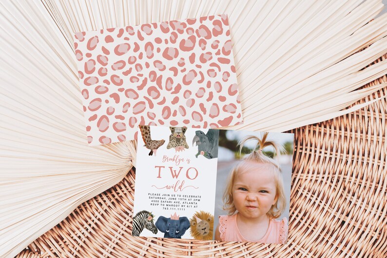 May include: Pink and white leopard print background with a pink and white invitation card. The card has a picture of a little girl and says "Brooklyn is TWO wild". The card also has a picture of a zebra, elephant, and lion.