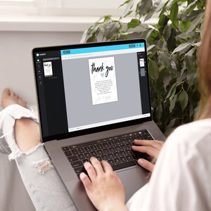 May include: A person is using a laptop to edit a thank you card with a blue heart design. The card says "Thank you" in a handwritten font. The text on the card reads "Thank you for making our day so special. We are so grateful for your presence and the wonderful gifts. We are so excited to start this new chapter in our lives. With love, [Name]"