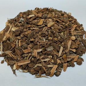 May include: A close-up of a pile of brown and tan bark chips. The bark chips are of various sizes and shapes.
