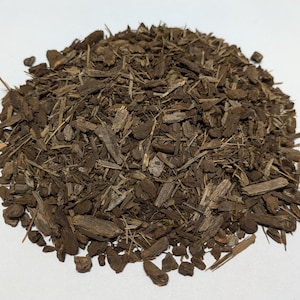May include: A pile of dark brown wood chips, likely for gardening or mulching.