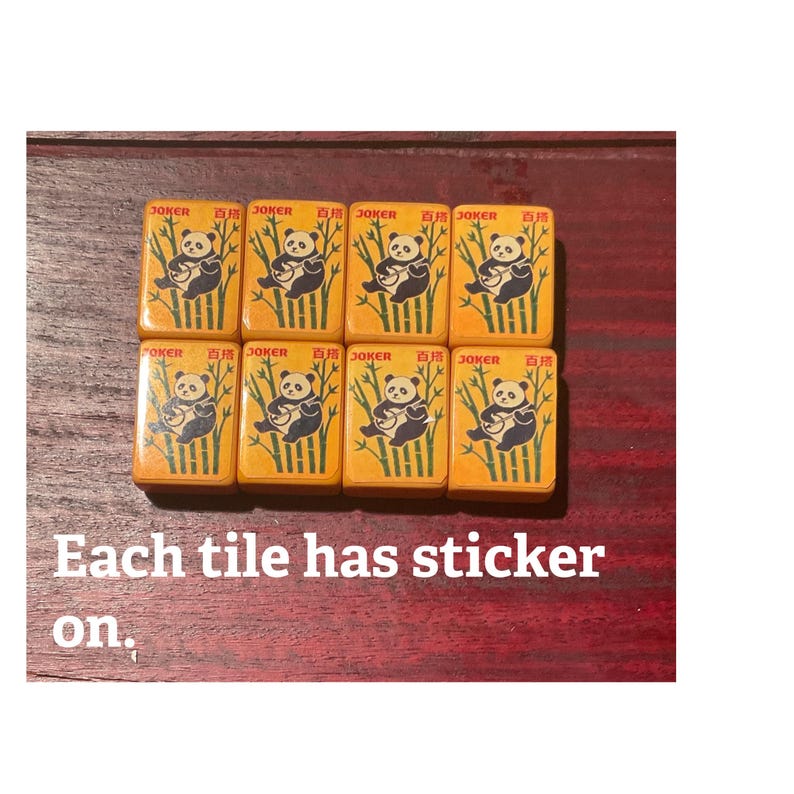 May include: Eight rectangular tiles with a panda bear illustration and Chinese characters. The tiles are orange with a bamboo design. The text "JOKER" is printed on each tile. The text "Each tile has sticker on." is also visible.