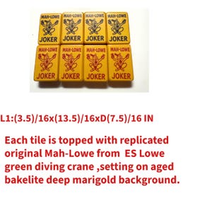 May include: Eight yellow Mah-Jongg tiles with "JOKER" and "MAH-LOWE" text. Each tile features a green diving crane design. The tiles are set on a deep marigold background. The dimensions are approximately 3.5 inches by 13.5 inches by 7.5 inches.
