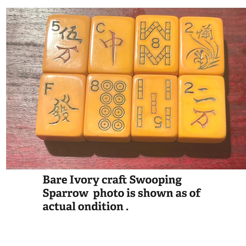 May include: Eight antique ivory-colored Mahjong tiles arranged on a wooden surface. The tiles feature various symbols, numbers, and Chinese characters. The text at the bottom reads "Bare Ivory craft Swooping Sparrow photo is shown as of actual ondition."