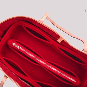 Pu&ograve; includere: Organizzatore per borsa in feltro rosso con pi&ugrave; scomparti e una tasca con cerniera. L'organizzatore &egrave; progettato per adattarsi all'interno di una borsa tote pi&ugrave; grande.