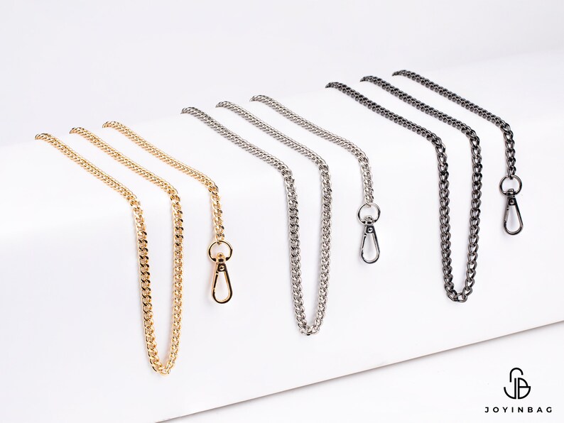 May include: Five different chain straps with lobster clasps. The chains are gold, silver, and black.