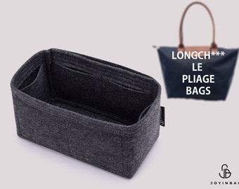 Könnte beinhalten: Ein dunkelgrauer Filz-Taschenorganizer mit mehreren Fächern. Der Organizer ist für die Innenseite einer Longchamp Le Pliage Tasche konzipiert. Der Text "LONGCH*** LE PLIAGE BAGS" ist im Hintergrund zu sehen.