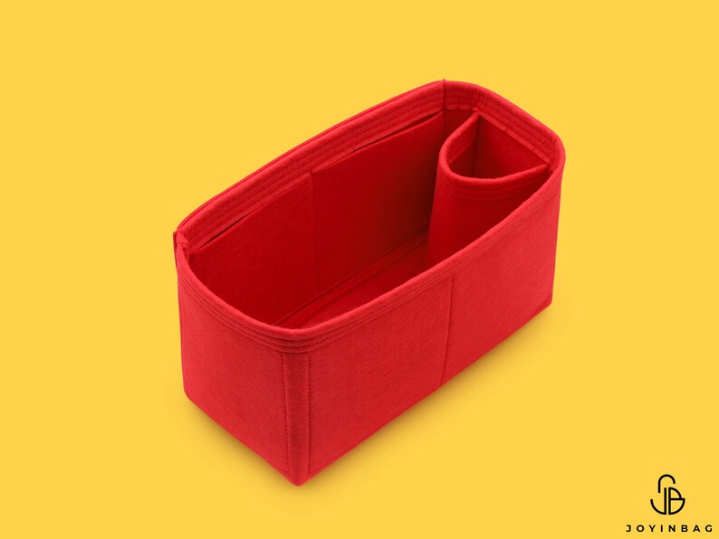 May include: Red felt bag organizer with multiple compartments and a small pocket. The organizer is designed to fit inside a larger bag.
