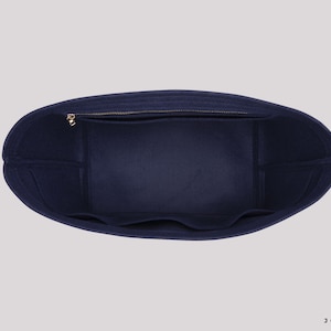 May include: Inside view of a navy blue felt tote bag with a zipped pocket and multiple compartments. The bag is designed to fit inside a larger tote bag.
