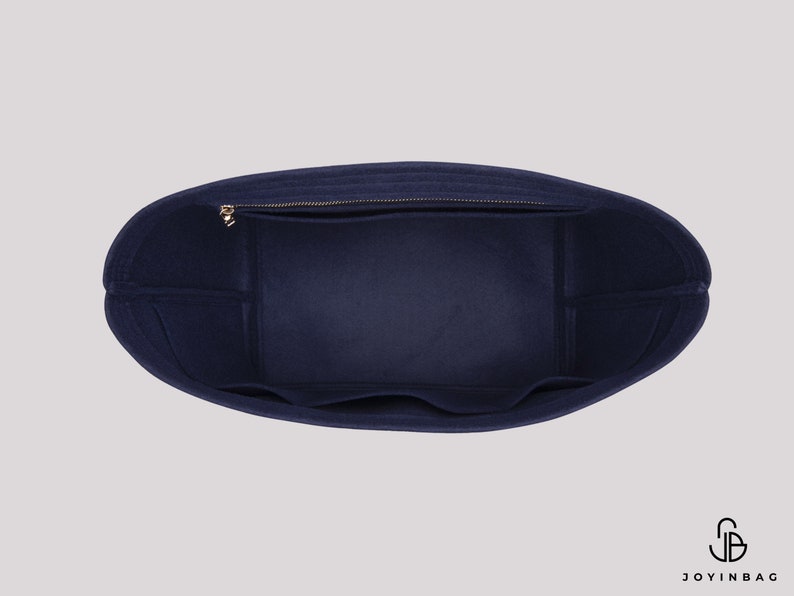 May include: Inside view of a navy blue felt tote bag with a zipped pocket and multiple compartments. The bag is designed to fit inside a larger tote bag.