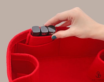May include: Red felt bag organizer with multiple compartments, including a large pocket for storing items like lipstick. The organizer is shown with three black lipstick tubes inserted into the pocket.