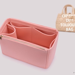 Könnte beinhalten: Rosa Filztaschenorganizer mit mehreren Fächern und Reißverschluss. Der Organizer ist für eine  "CH**D** TOUJOURS BAG" konzipiert.