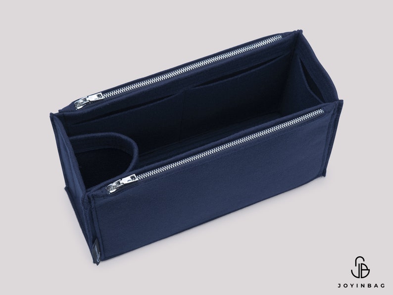 May include: A navy blue felt bag organiser with multiple compartments and zipper closures. The organiser is designed to fit inside a larger bag, helping to keep items organised.