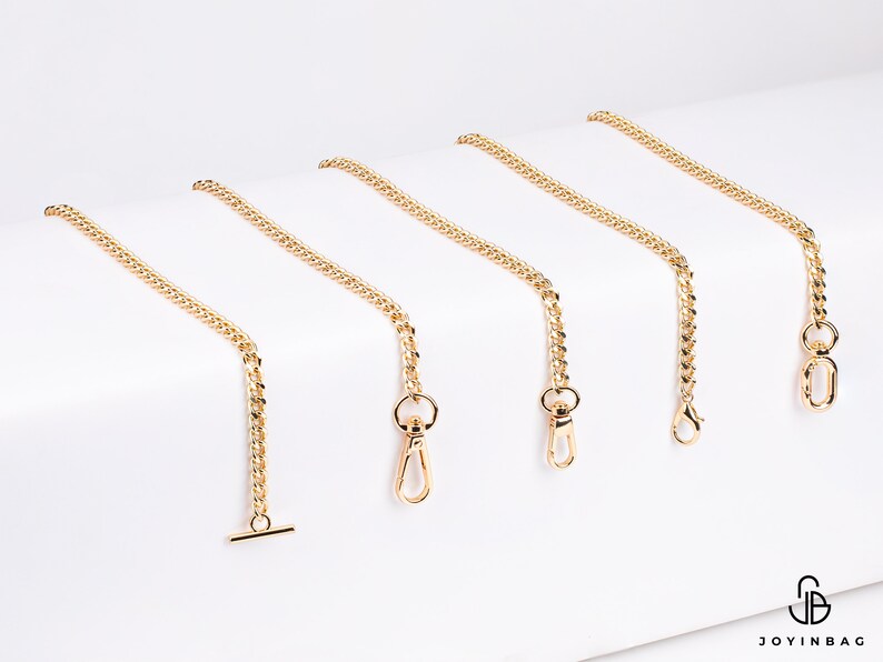 May include: Five gold chain straps with different lengths and clasps. The chains are on a white background.