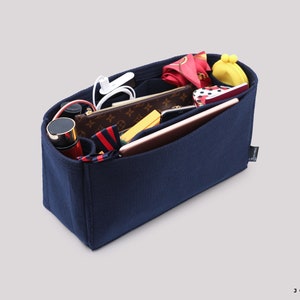 May include: A navy blue felt bag organizer with multiple compartments and pockets. The organizer is filled with various items, including a phone, wallet, and makeup.