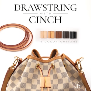 Può includere: Una borsa a secchiello con motivo a scacchi bianco e grigio, finiture in pelle color cuoio e dettagli dorati. La borsa presenta una chiusura a coulisse con un fermacorda. Sono inclusi un laccio in pelle arrotolato e cinque colori.