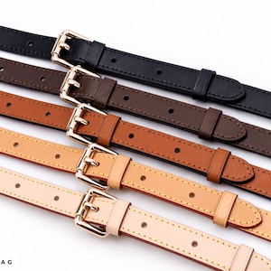 May include: Five thin leather straps in black, dark brown, medium brown, tan, and beige, each featuring a polished gold-tone metal buckle, matching belt loops, and evenly spaced adjustment holes. The logo JOYINBAG is printed in the bottom left corner.