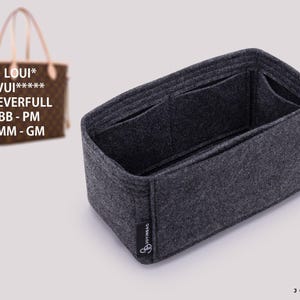 May include: A dark gray felt handbag organizer insert with multiple interior compartments and a rectangular shape. A small black fabric tag with the text JOYINBAG is attached to the side. A brown patterned tote bag is visible in the background.