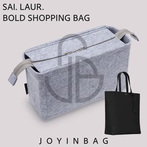 May include: A light gray felt bag organizer with a zippered top closure, designed for a tote. The text SAI. LAUR. BOLD SHOPPING BAG and JOYINBAG appear on the image, alongside a small black tote bag with two handles and a hanging luggage tag.