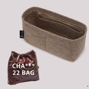 May include: Beige felt bag organizer with multiple compartments and a zippered pocket. The bag is empty and the interior is visible. The text "CHA*** 22 BAG" is printed on the bag.