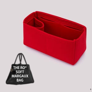 May include: A bright red handbag organizer with multiple compartments. The organizer is rectangular with a structured design and is designed to fit inside a bag. The text "THE RO* SOFT MARGAUX BAG" is visible on a black handbag in the image.