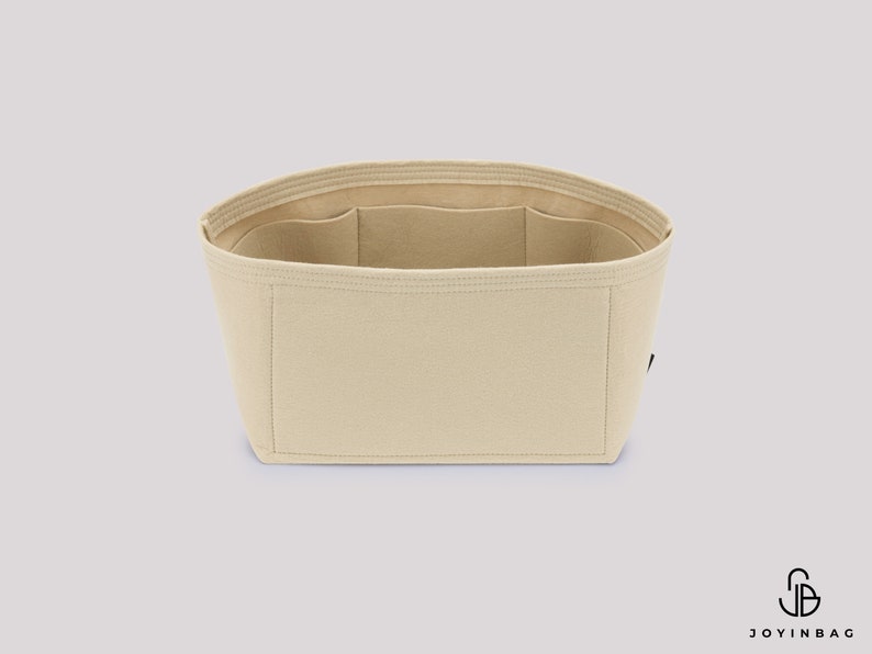 Pu&ograve; includere: Organizzatore per borsa in feltro beige con pi&ugrave; scomparti. L'organizzatore &egrave; progettato per adattarsi all'interno di una borsa pi&ugrave; grande e aiutare a mantenerla organizzata.