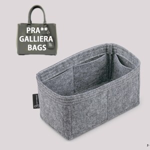 Könnte beinhalten: Ein grauer Filz-Taschenorganizer mit mehreren Fächern und Taschen. Der Organizer ist für eine Prada Galleria Tasche konzipiert. Der Text "PRA** GALLIERA BAGS" ist auf der Tasche sichtbar.