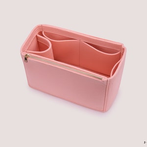 K&ouml;nnte beinhalten: Ein rosa Filztaschenorganizer mit mehreren F&auml;chern und einem Rei&szlig;verschluss. Der Organizer ist so konzipiert, dass er in eine gr&ouml;&szlig;ere Tasche passt.