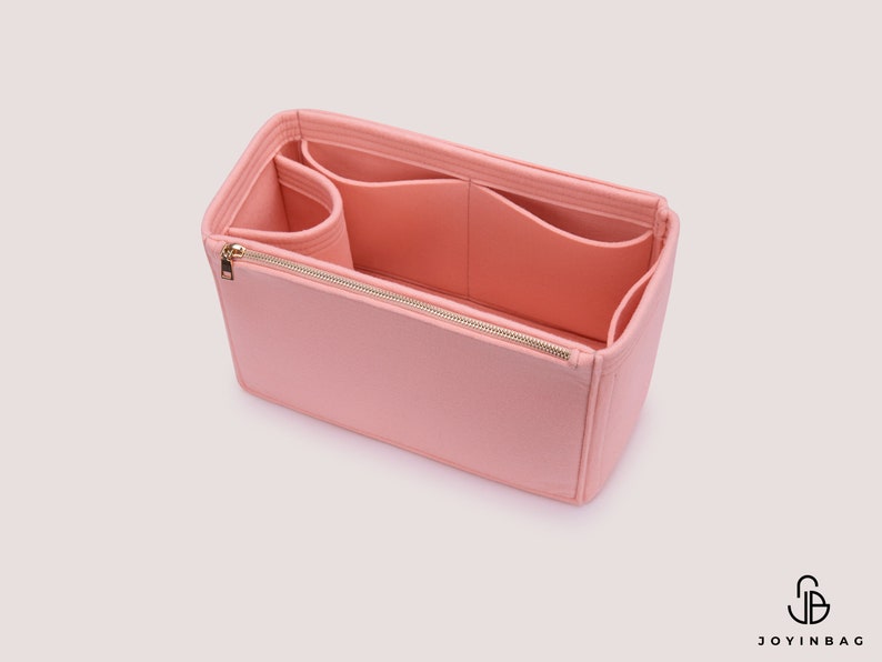 K&ouml;nnte beinhalten: Ein rosa Filztaschenorganizer mit mehreren F&auml;chern und einem Rei&szlig;verschluss. Der Organizer ist so konzipiert, dass er in eine gr&ouml;&szlig;ere Tasche passt.
