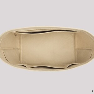 Pu&ograve; includere: Inserito per borsa in feltro beige con pi&ugrave; scomparti e una tasca con cerniera. L'inserto &egrave; progettato per adattarsi all'interno di una borsa tote pi&ugrave; grande per aiutare a organizzare il contenuto.