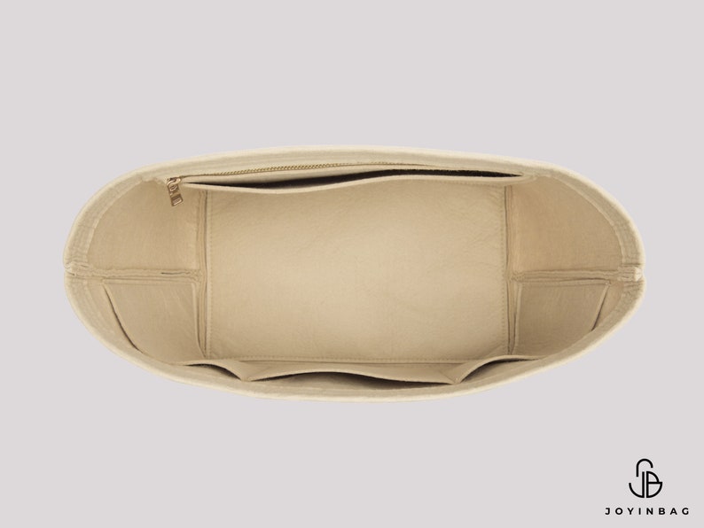 Pu&ograve; includere: Inserito per borsa in feltro beige con pi&ugrave; scomparti e una tasca con cerniera. L'inserto &egrave; progettato per adattarsi all'interno di una borsa tote pi&ugrave; grande per aiutare a organizzare il contenuto.
