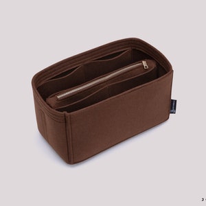 K&ouml;nnte beinhalten: Brauner Filztaschenorganizer mit mehreren F&auml;chern und einer Rei&szlig;verschlusstasche. Der Organizer ist so konzipiert, dass er in eine gr&ouml;&szlig;ere Tasche passt und hilft, sie zu organisieren.