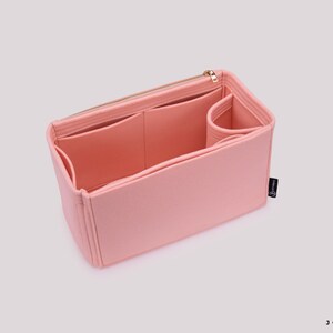 K&ouml;nnte beinhalten: Ein rosa Filztaschenorganizer mit mehreren F&auml;chern und einem Rei&szlig;verschluss. Der Organizer ist so konzipiert, dass er in eine gr&ouml;&szlig;ere Tasche passt und hilft, sie zu organisieren.