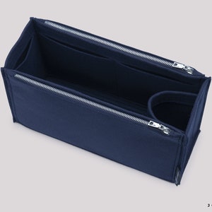 May include: A navy blue felt bag organiser with multiple compartments and a zipper closure. The organiser is designed to fit inside a larger bag and help keep it organised.
