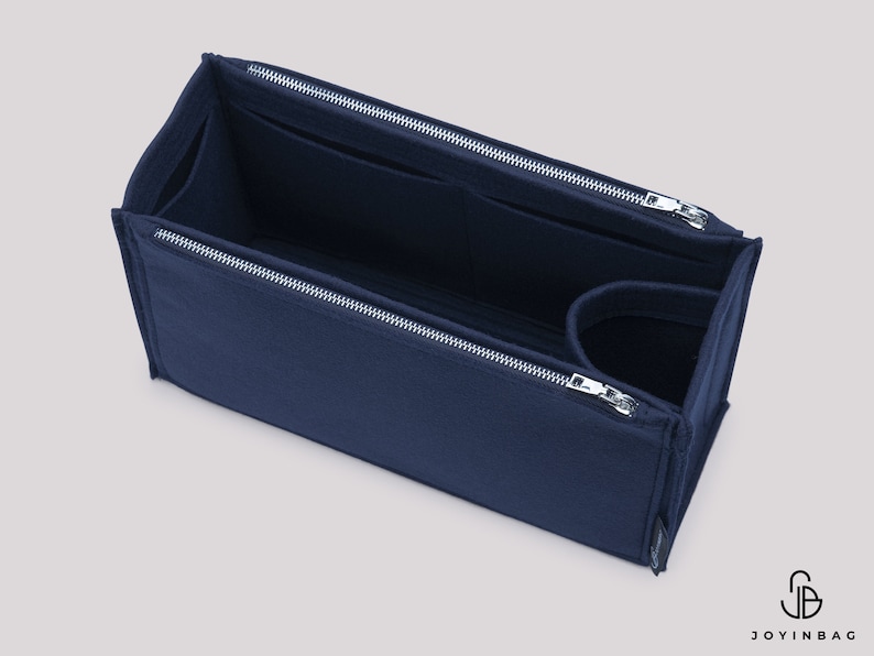 May include: A navy blue felt bag organiser with multiple compartments and a zipper closure. The organiser is designed to fit inside a larger bag and help keep it organised.