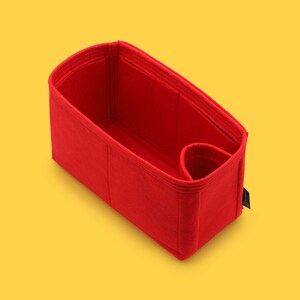May include: Red felt bag organizer with multiple compartments and a small pocket. The organizer is designed to fit inside a larger bag.