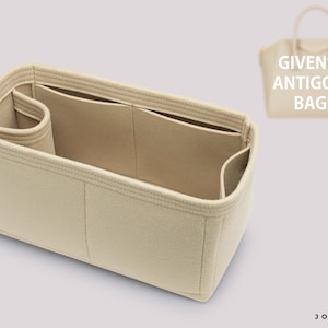 Puede incluir: Organizador de bolso de fieltro beige con múltiples compartimentos. El organizador está diseñado para caber dentro de un bolso Givenchy Antigona. El texto "GIVEN*** ANTIGONA BAGS" es visible en el fondo.