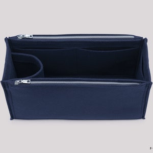 May include: A navy blue felt bag organiser with multiple compartments and a zipper closure. The organiser is designed to fit inside a larger bag and help keep it organised.