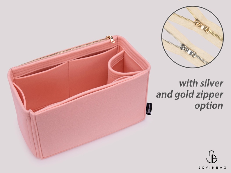K&ouml;nnte beinhalten: Rosa Filztasche Organizer mit mehreren F&auml;chern und Rei&szlig;verschluss. Der Taschenorganizer ist ge&ouml;ffnet und leer dargestellt. Das Bild zeigt auch eine Nahaufnahme eines silbernen und goldenen Rei&szlig;verschlusses.