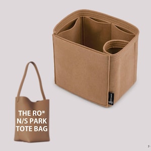 Puede incluir: Un bolso tote de color beige y un organizador de fieltro a juego. El bolso tote tiene un asa y el texto "THE RO* N/S PARK TOTE BAG". El organizador tiene múltiples compartimentos y una sección cilíndrica. El logotipo de Joyinbag es visible.