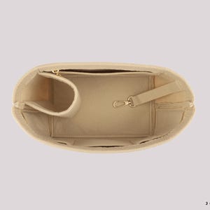 May include: Beige handbag organizer with multiple compartments, including a zippered pocket, a pen holder, and a key clip. The organizer is designed to fit inside a larger bag and keep items organized. The logo "JOYINBAG" is visible in the bottom right corner.