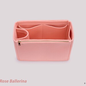 K&ouml;nnte beinhalten: Ein rosa Filz-Taschenorganizer mit mehreren F&auml;chern und einem Rei&szlig;verschluss. Die Tasche ist offen und das Innere ist sichtbar. Der Text "Color Rose Ballerina" ist unten im Bild zu sehen.
